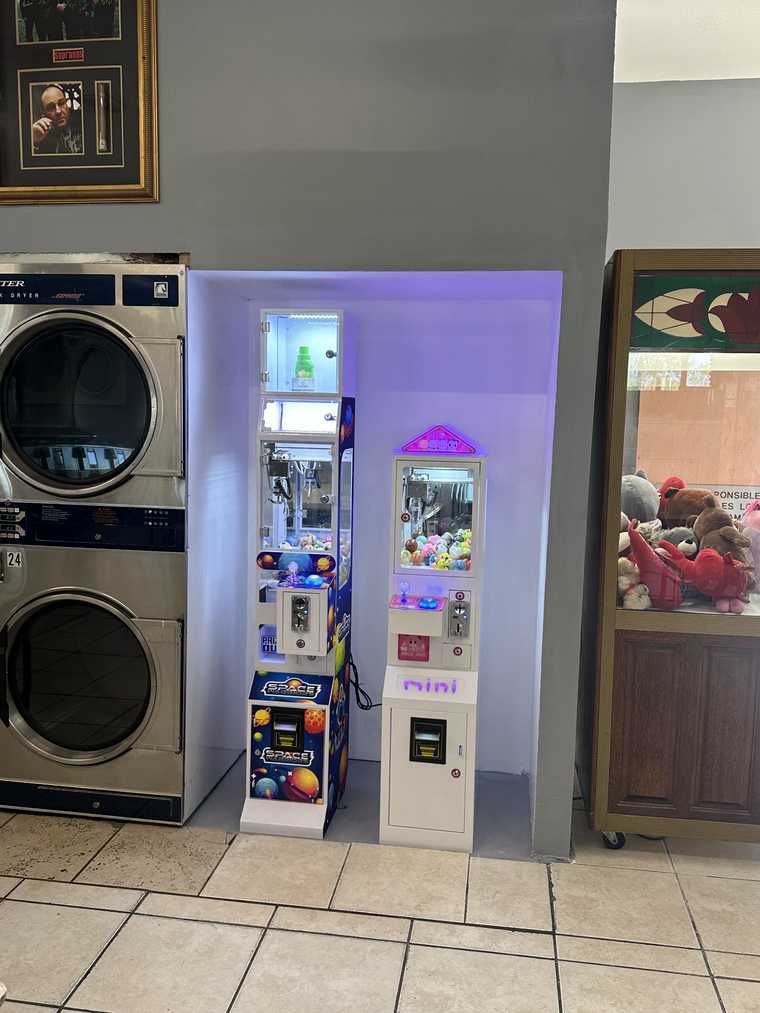 Claw machines and stacked dryers inside Coastal Clean Laundromat