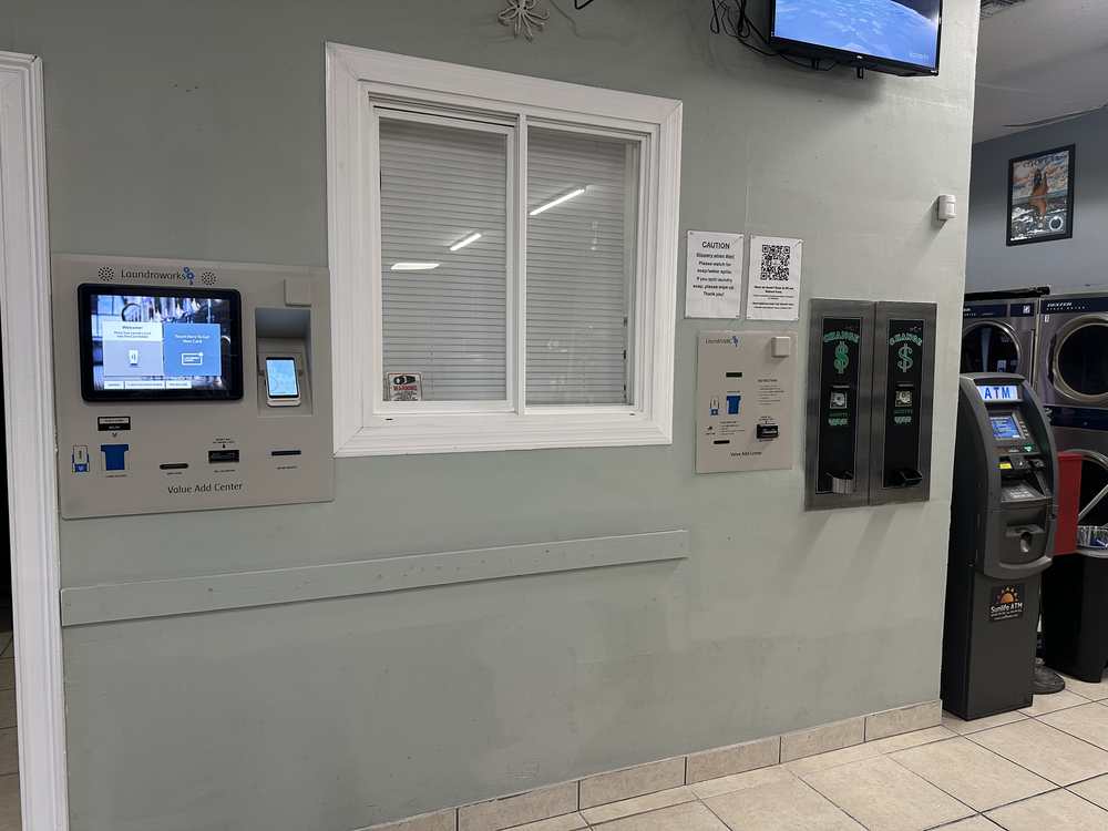LaundroWorks payment kiosk, laundry card dispensers, and ATM inside Coastal Clean Laundromat